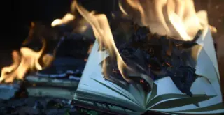 на фотографии горит раскрытая книга